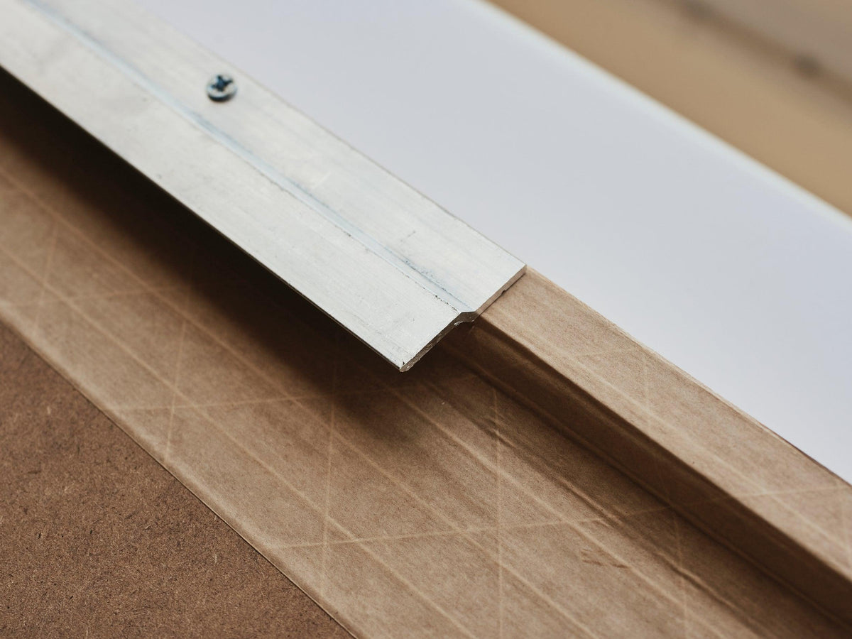 Close-up of a metal Z-bar hanging bracket fixed to the back of an artwork frame