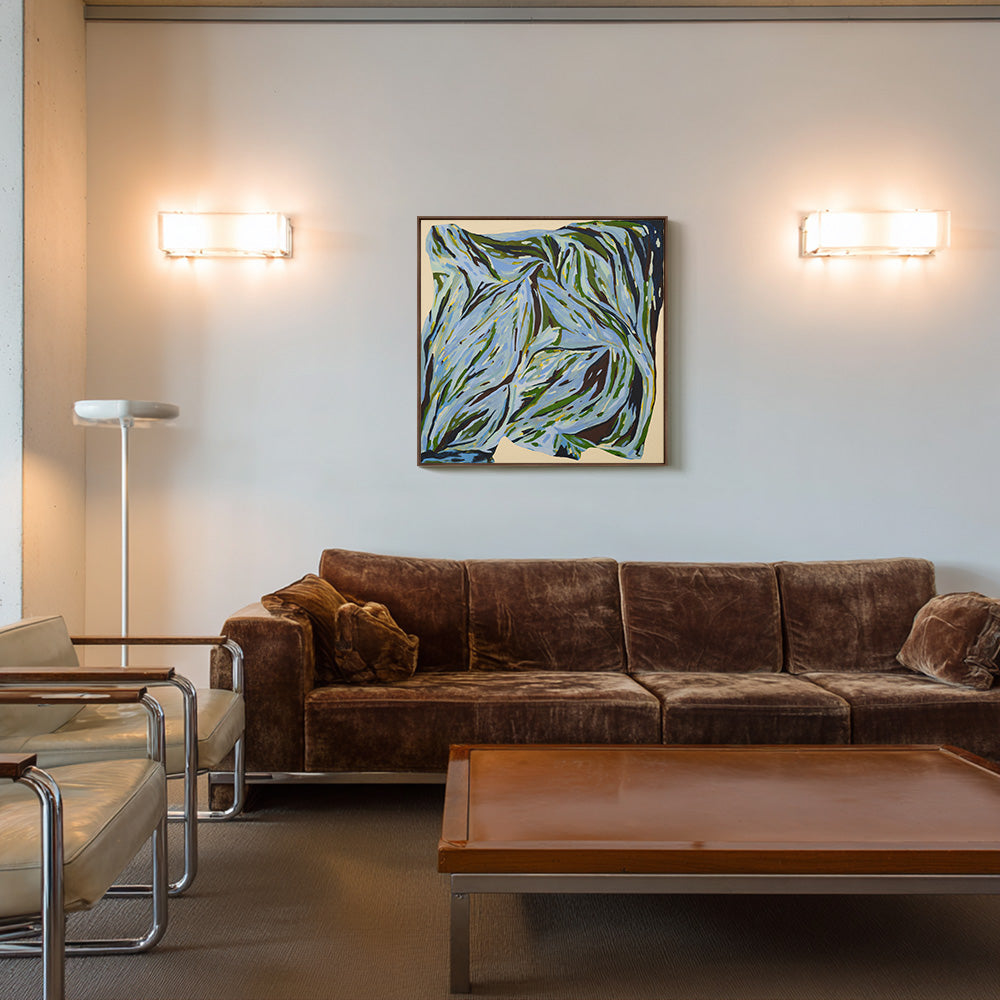 Framed square painting with abstract blue and green brushstrokes hanging above a brown velvet sofa