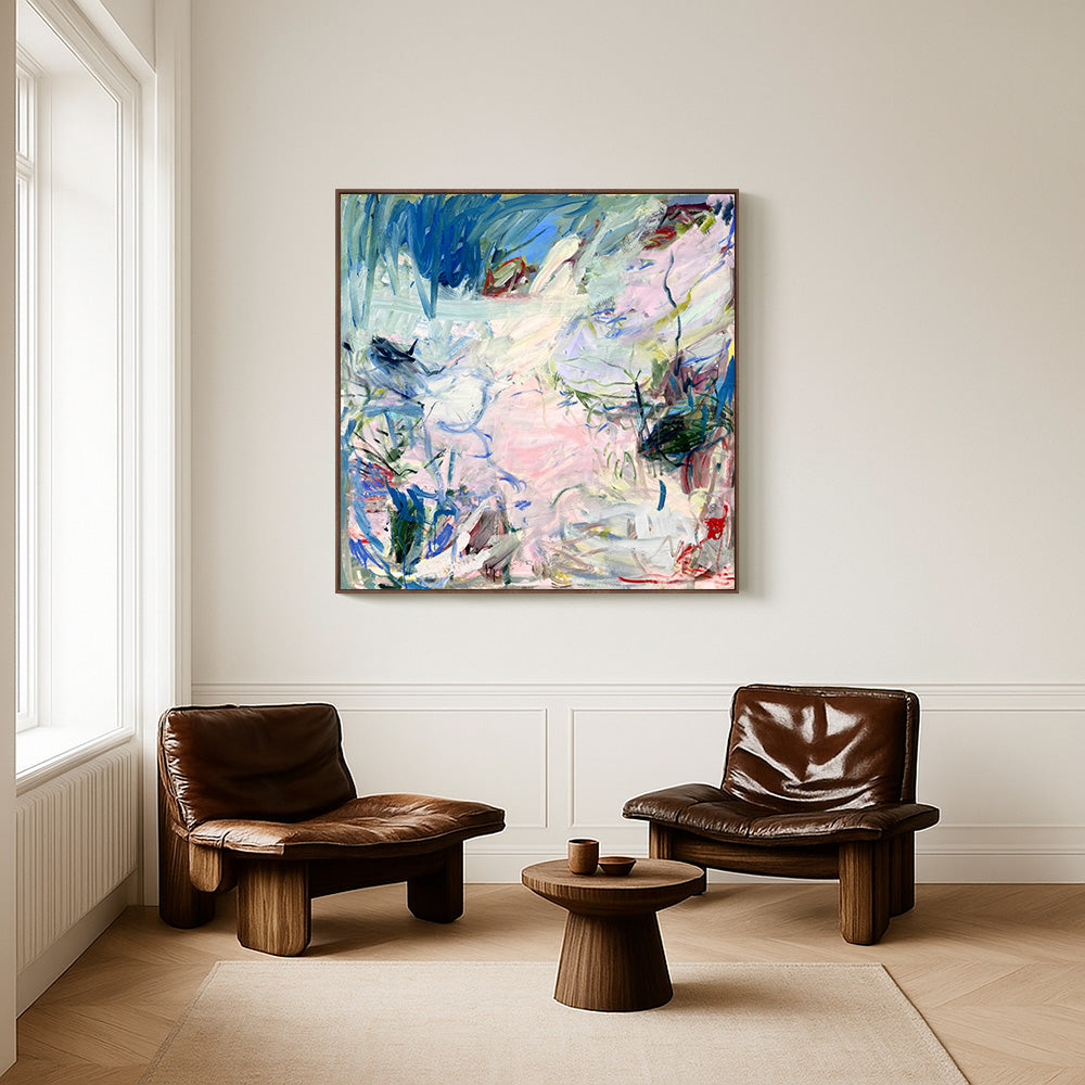 Abstract blue and pink painting displayed above two leather lounge chairs in a bright minimalist room