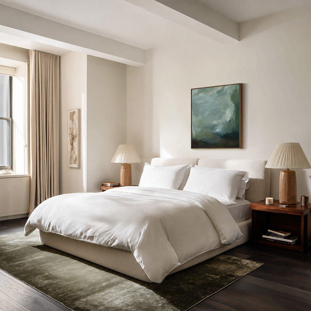 Bedroom with white bed wooden nightstands lamps and a large abstract painting in blues and greens above the bed