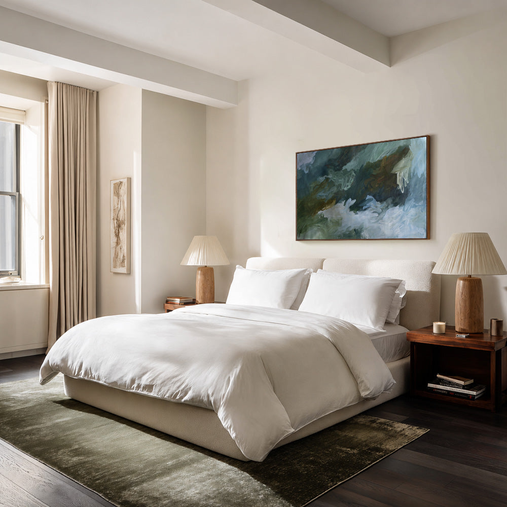 Abstract painting with swirling blue green and brown hues hanging above a white bed in a bedroom setting
