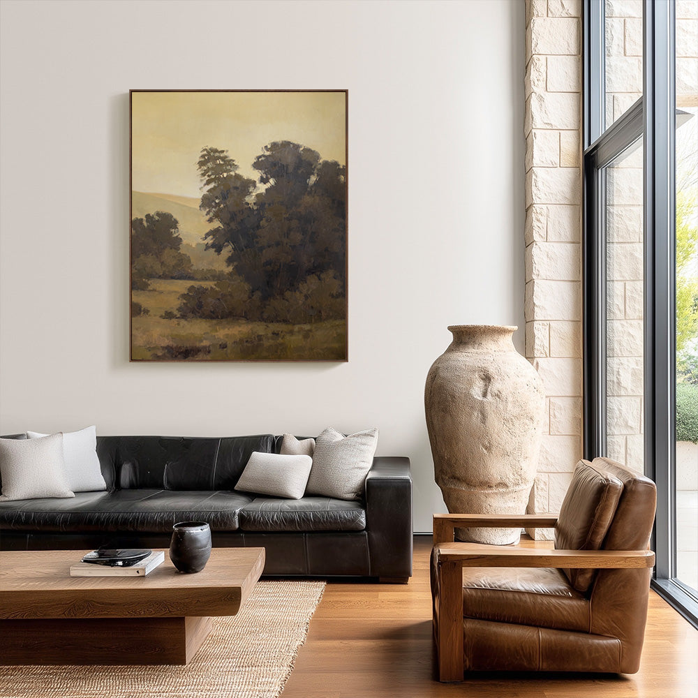 Original 62x50 landscape painting "Field Notes in Umber" by Ashley Ozmint. Trees in grassy field with hills and a cloudy sky. Painting in modern living room.