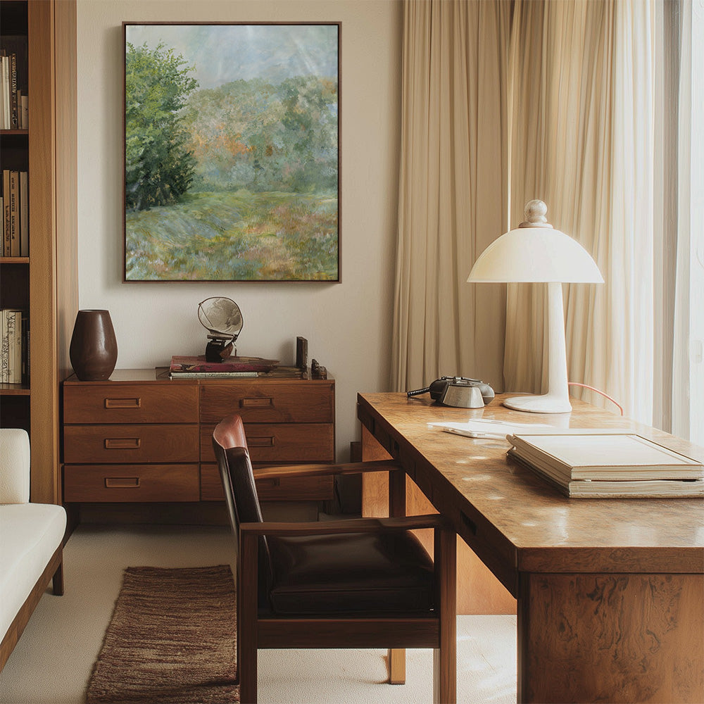 Impressionistic forest meadow painting hangs above a wooden desk in a well-lit office