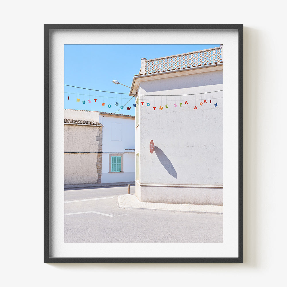 Down to the Sea print in a black frame featuring colorful letters spelling I MUST GO DOWN TO THE SEA AGAIN