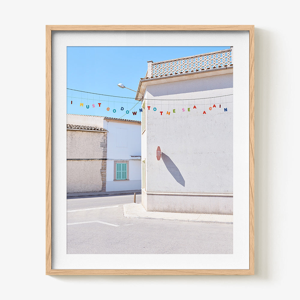 Down to the Sea print in a natural wood frame featuring colorful letters spelling I MUST GO DOWN TO THE SEA AGAIN