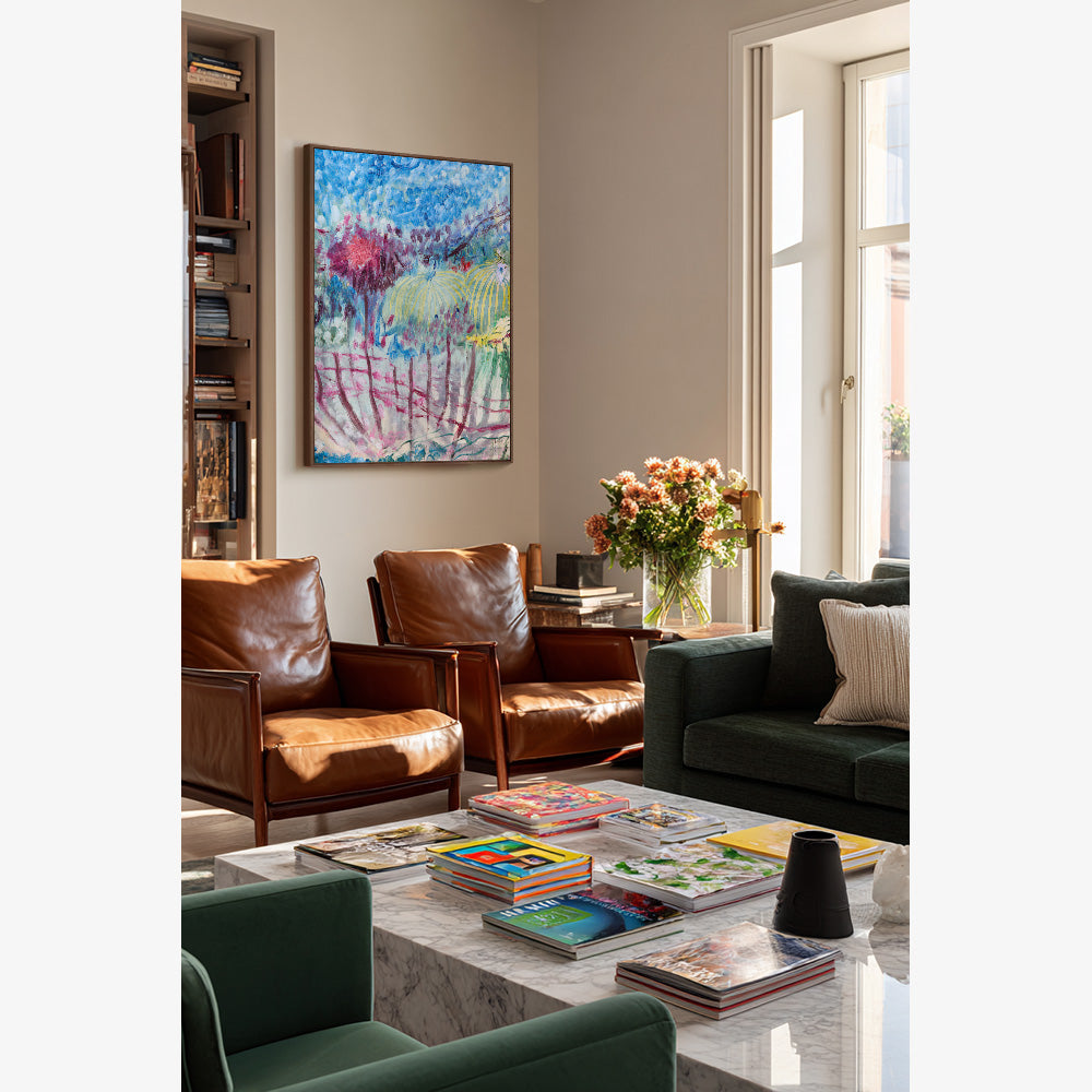 Abstract painting with bold blue and pink strokes hanging on a wall in a furnished living area