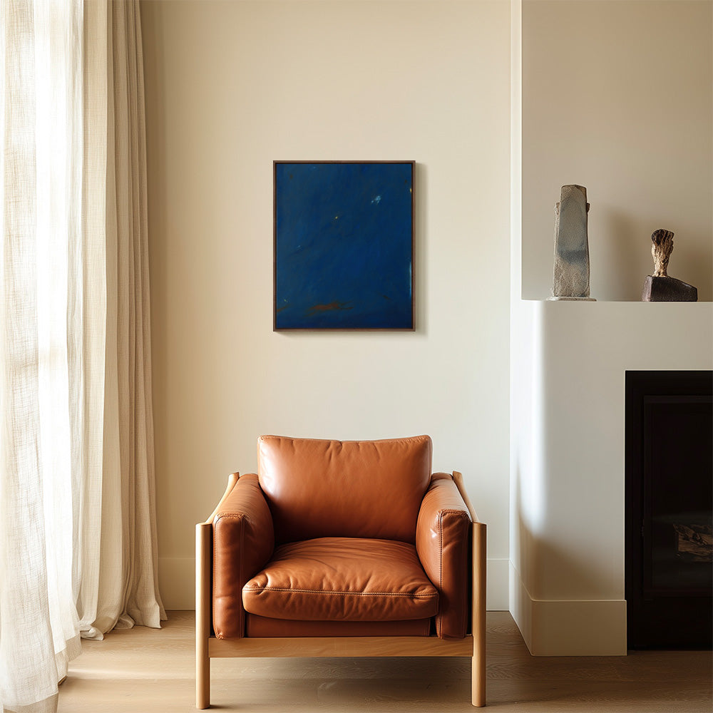 Abstract painting Nocturnal Current II framed hanging above a tan leather armchair with a natural wood frame