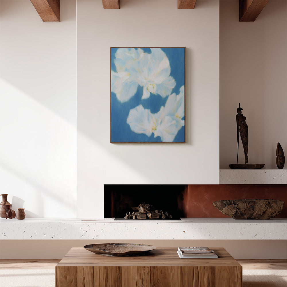 Abstract painting with two large white blossoms on a blue background hanging above a fireplace in a modern living room