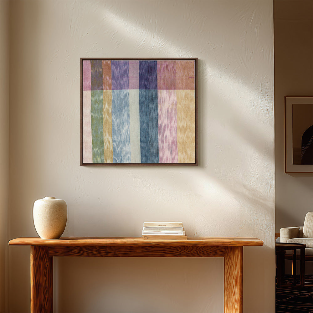 Textile art hanging on a light wall above a wooden console table