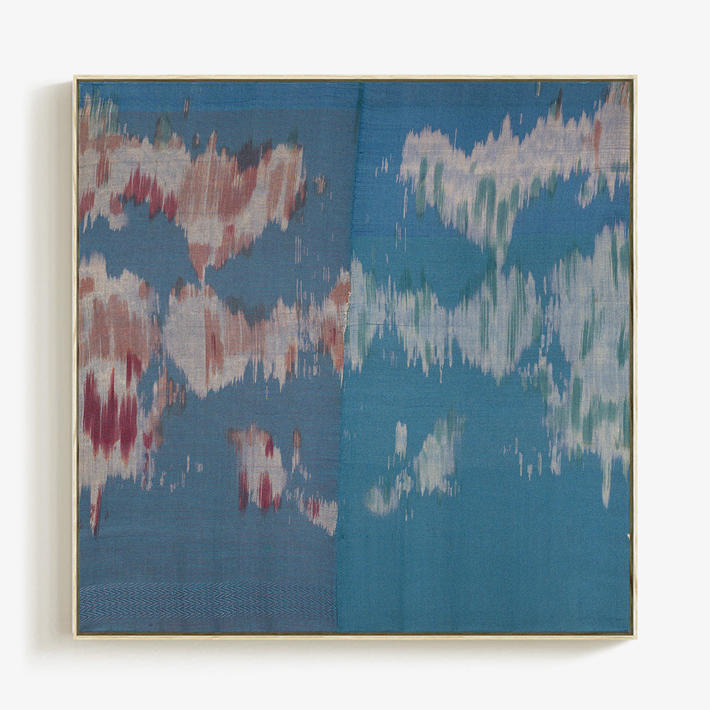 Abstract textile art in a gold frame featuring blended blue grey and reddish-brown blurred color patterns