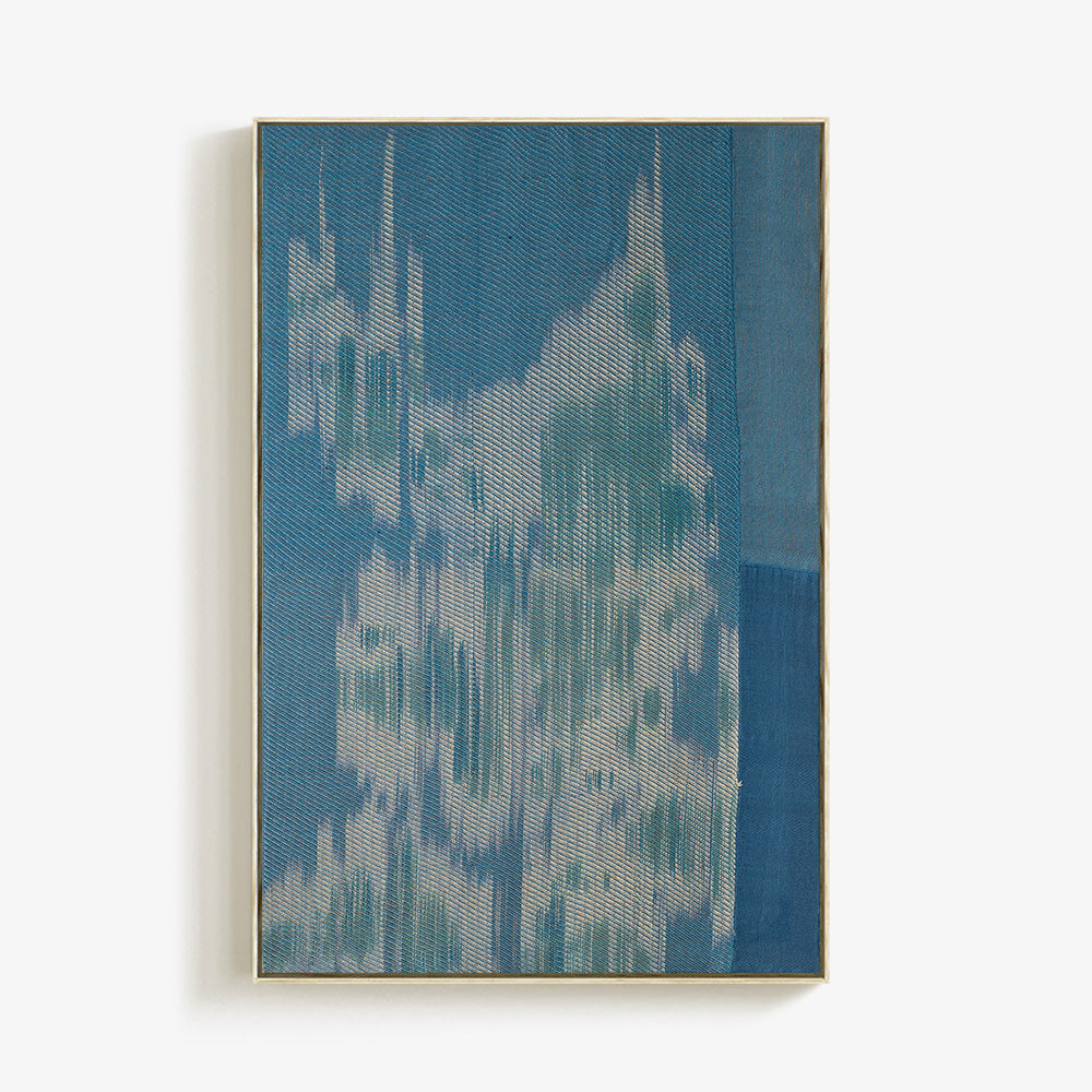 Vertical rectangular textile piece with blue and white abstract woven textures in a thin gold frame