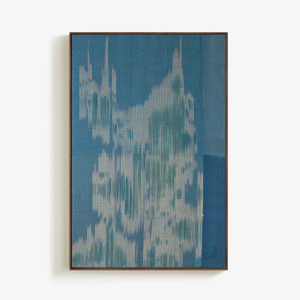 Vertical rectangular textile piece with blue and white abstract woven textures in a brown frame