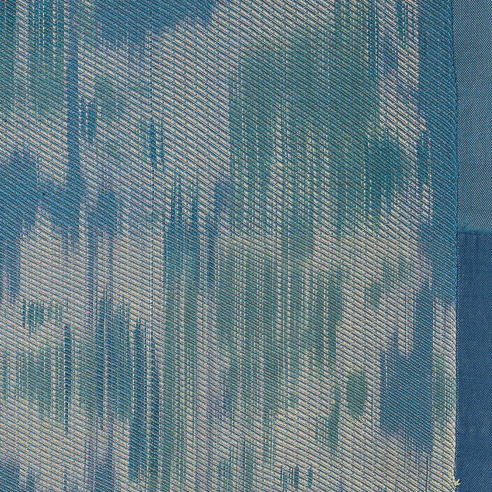 Close-up of a blue and white woven textile with vertical abstract light and dark patterns