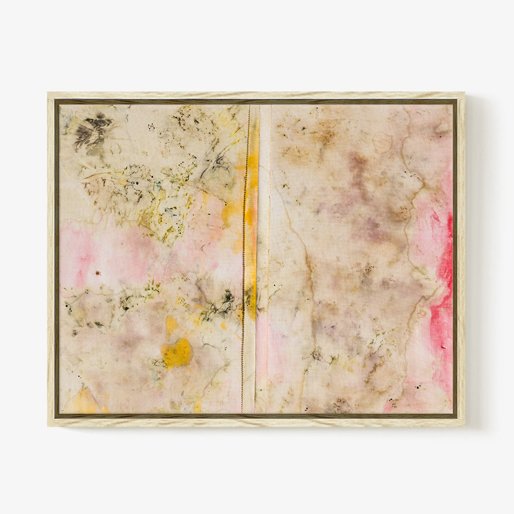 Textile wall art with beige pink and yellow blotchy pigments and a central vertical seam in a light wood frame