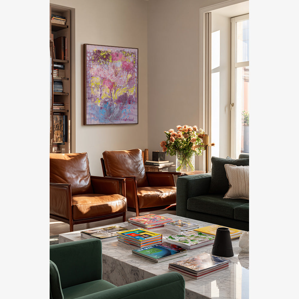 Abstract painting showing vibrant pink and yellow floral-inspired shapes displayed in a modern home interior