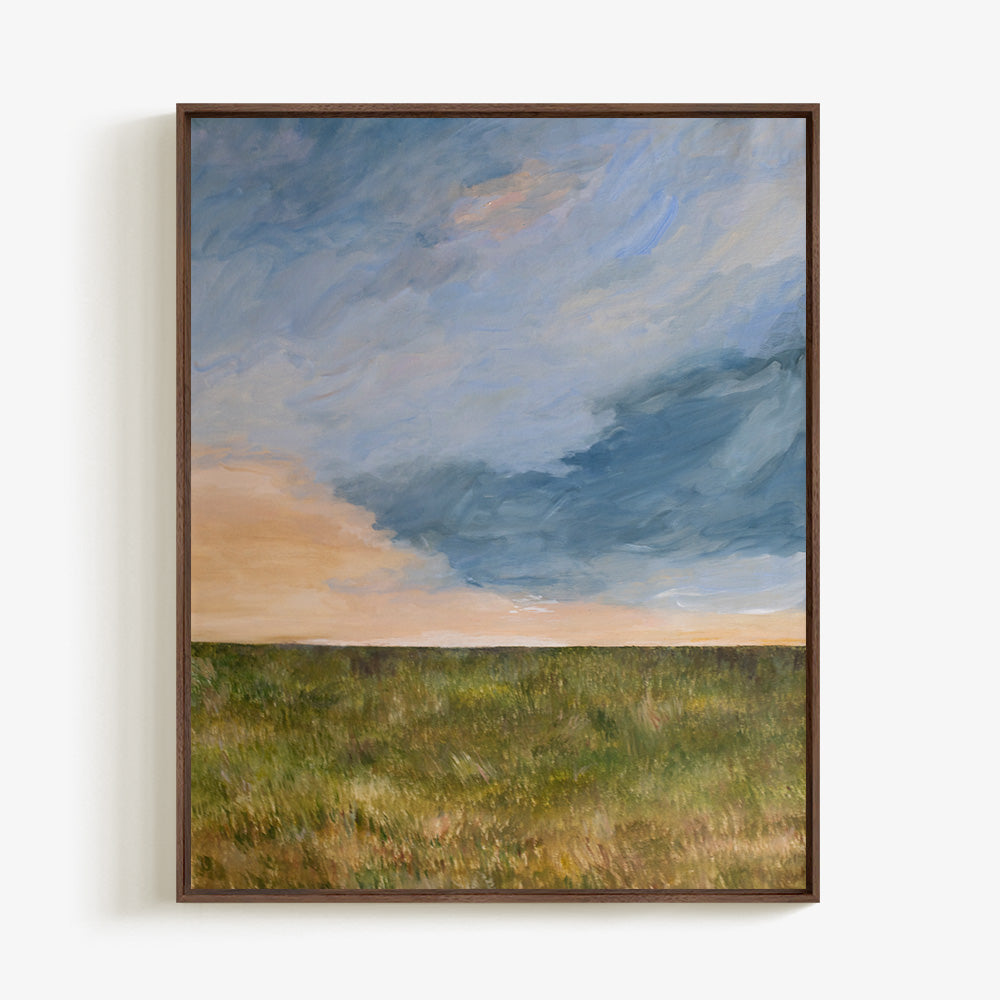 Vertical landscape painting titled A Field at Sunset in a dark wood frame with a blue and orange sky over a green field