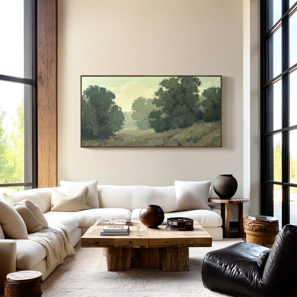 Original 36x72 landscape painting "Begin Anew" by Ashley Ozmint.  Trees in grassy field with a cloudy sky. Painting in modern living room.