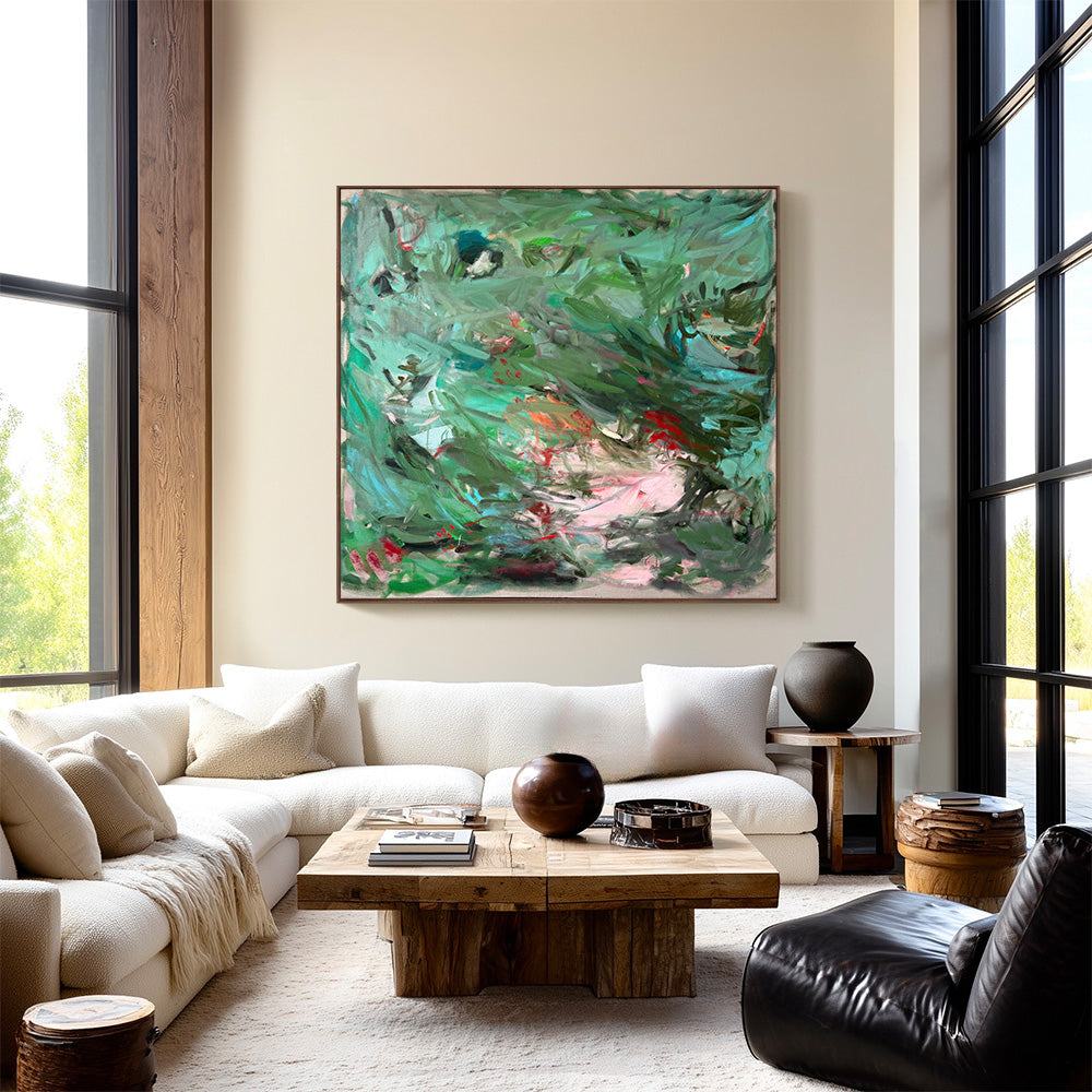 Abstract green and pink painting hanging above a white sectional sofa in a modern living room
