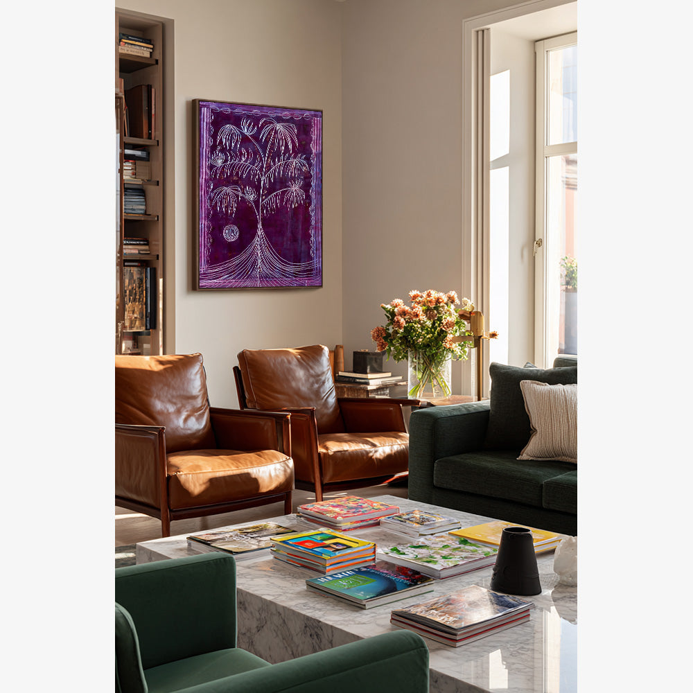 Painting of a stylized tree in vibrant purple hues hanging on a living room wall above leather armchairs