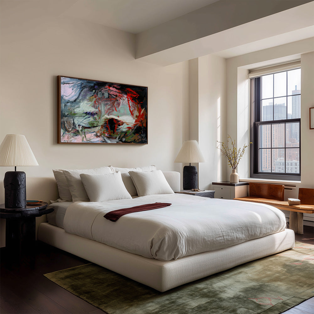 Modern bedroom setting with a framed abstract painting by Petra Schott hung on a neutral wall above the headboard