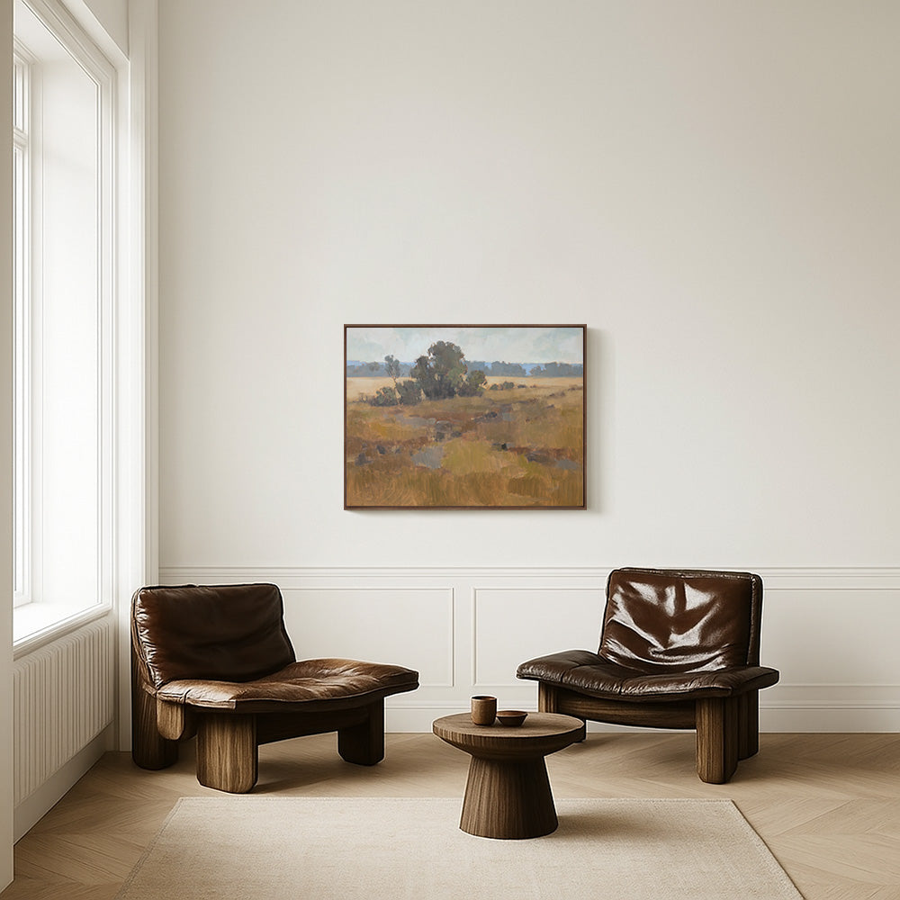 Original 30x40 landscape painting "Growing Unguarded" by Ashley Ozmint.  Trees in grassy field with a cloudy sky.  Painting in room with two chairs.