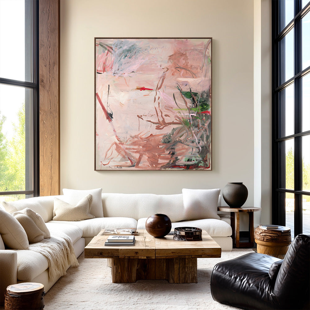 Abstract artwork hung above a white sectional sofa in a modern light-filled living room with large windows