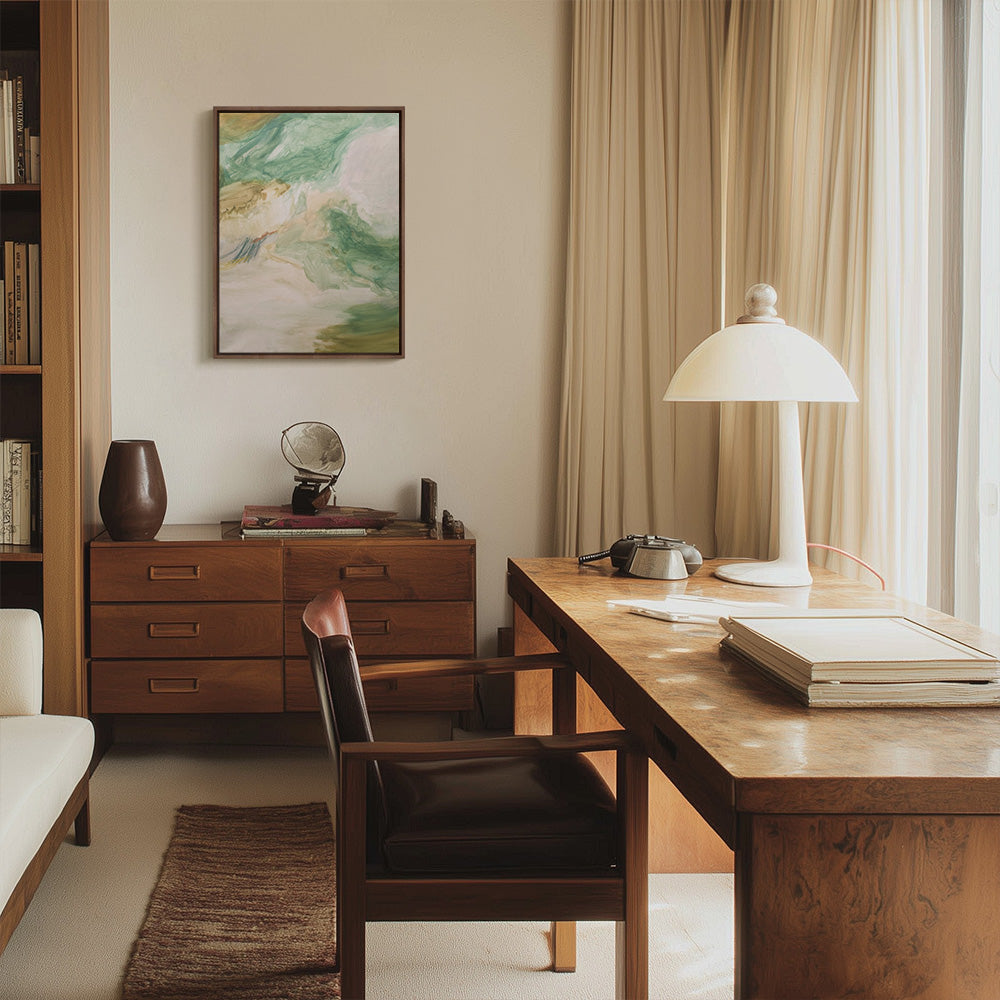 A painting with pale green beige and white brushstrokes hangs above a wooden credenza in a sunlit office