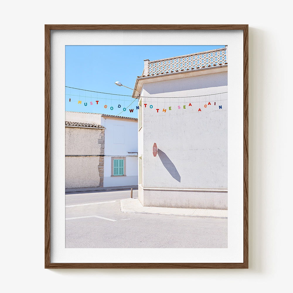 Down to the Sea print in a dark wood frame featuring colorful letters spelling I MUST GO DOWN TO THE SEA AGAIN