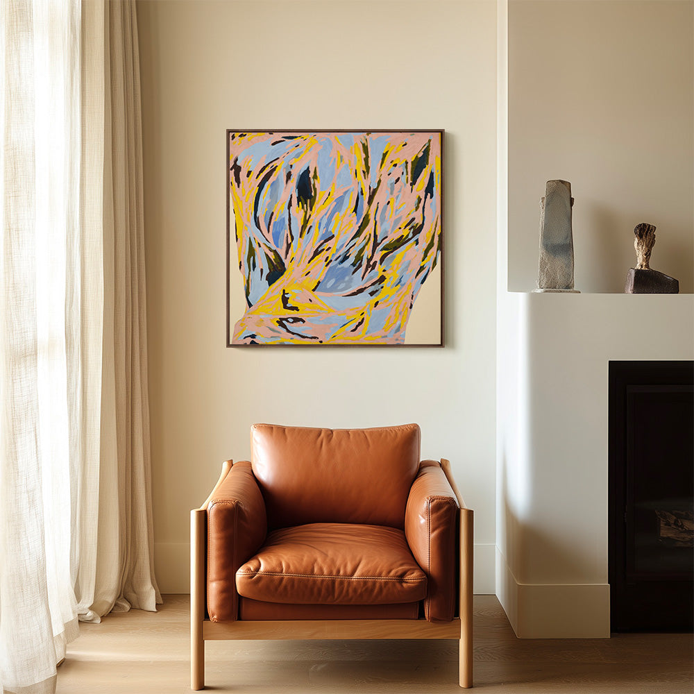 Modern interior featuring a framed abstract painting with pink yellow and blue hues above a leather armchair