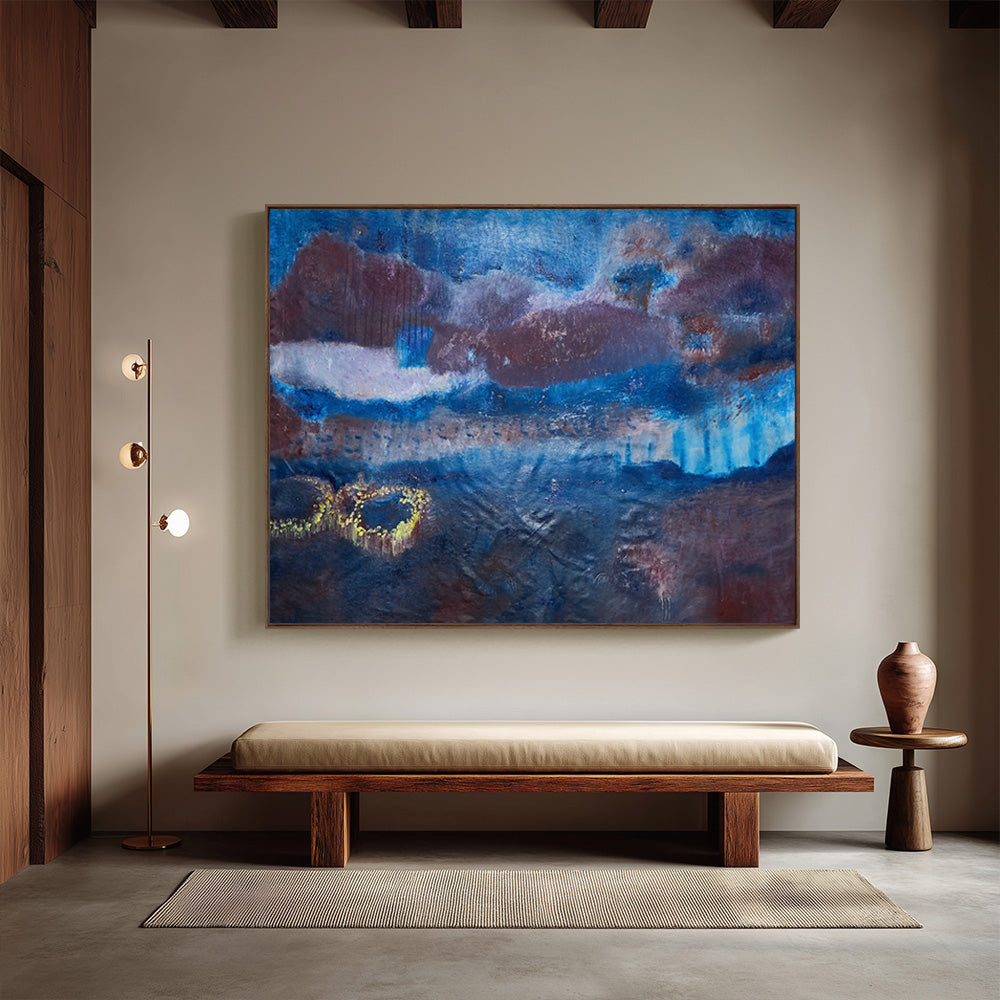 Abstract oil painting with dark blue and deep red tones and gold floral accents mounted in a contemporary room