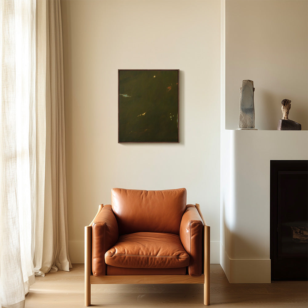 Living area with a dark framed abstract painting hanging above a brown leather lounge chair