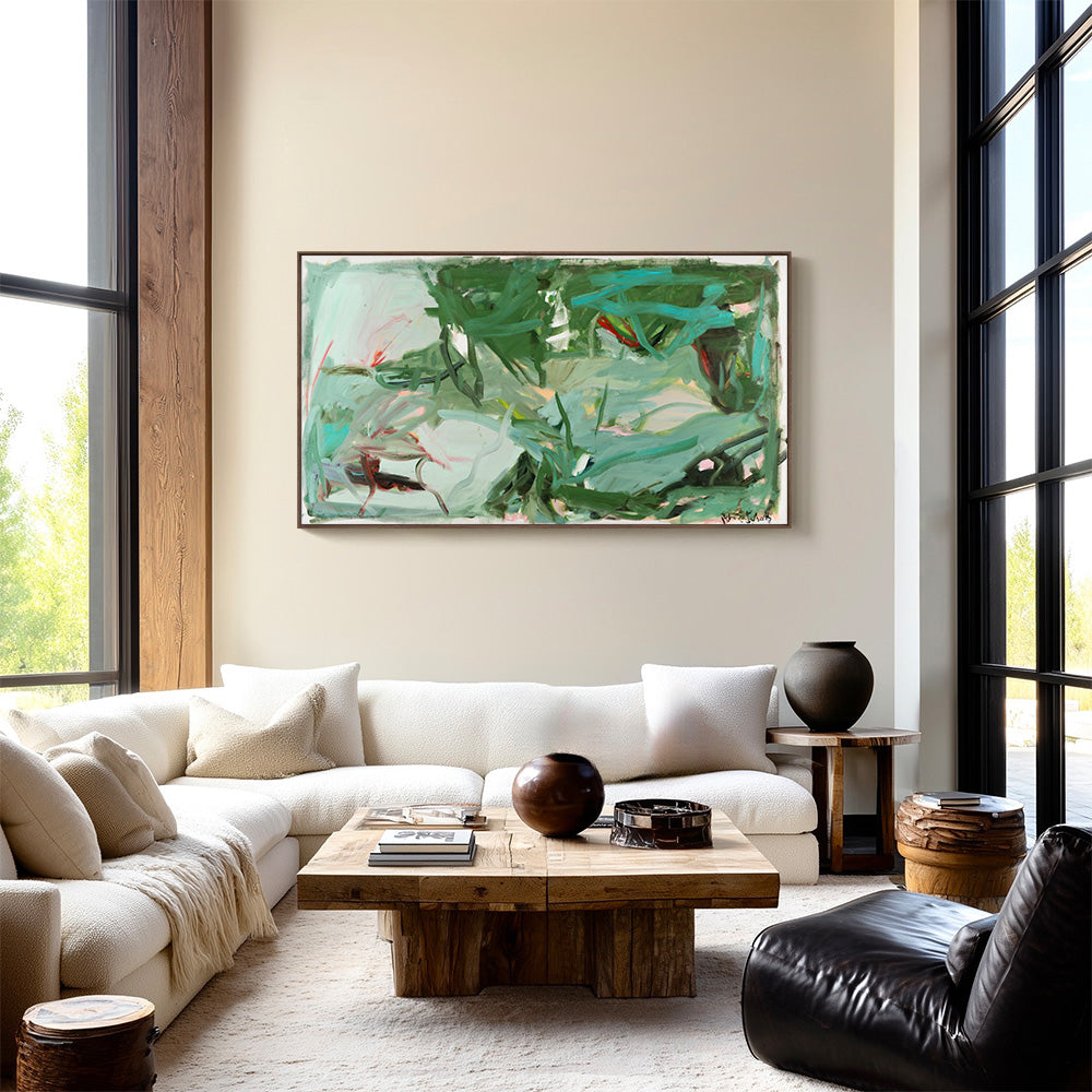 Room interior featuring a horizontal green abstract painting above a white sofa and natural wood coffee table