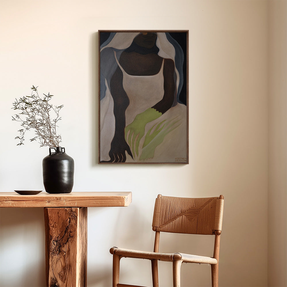 Painting of a figure in a white dress and veil with green hands hanging on a wall next to a wooden table and chair