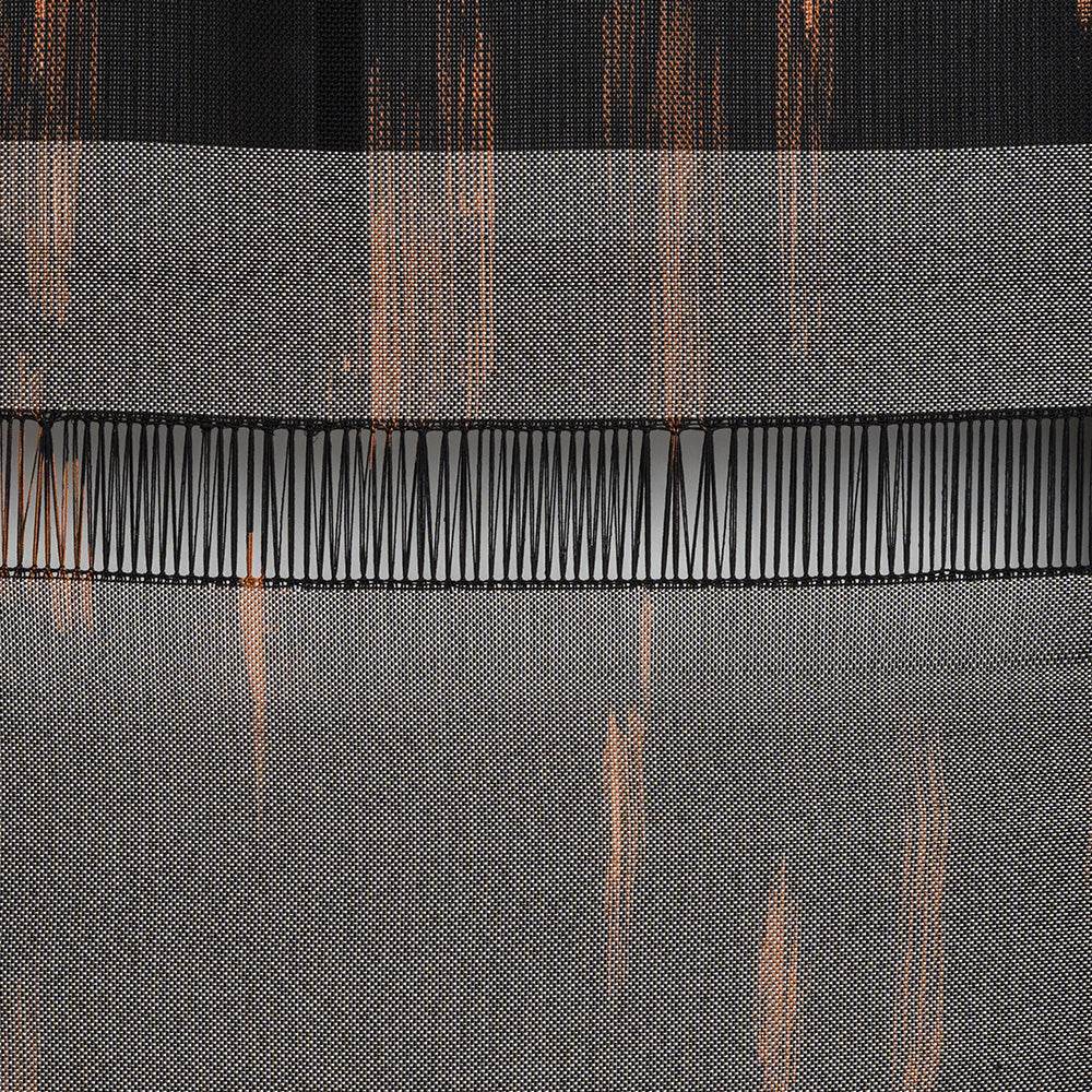 Detail of a black and orange woven textile showing horizontal lines and a section of open fringe-like weave