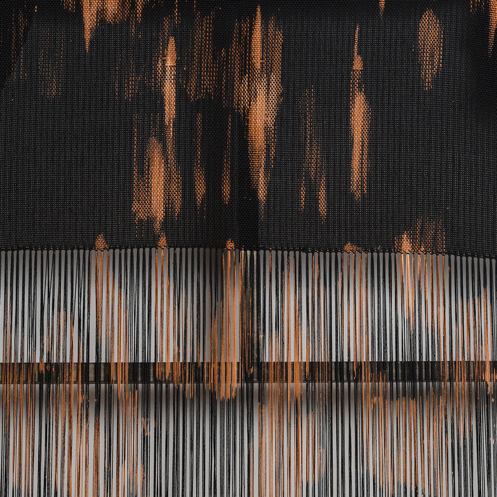 Detail view of a woven textile with a black background and thin vertical orange and grey thread accents