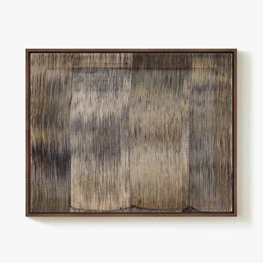 Framed textile wall art with abstract vertical tonal brown and gray streaks on textured woven material